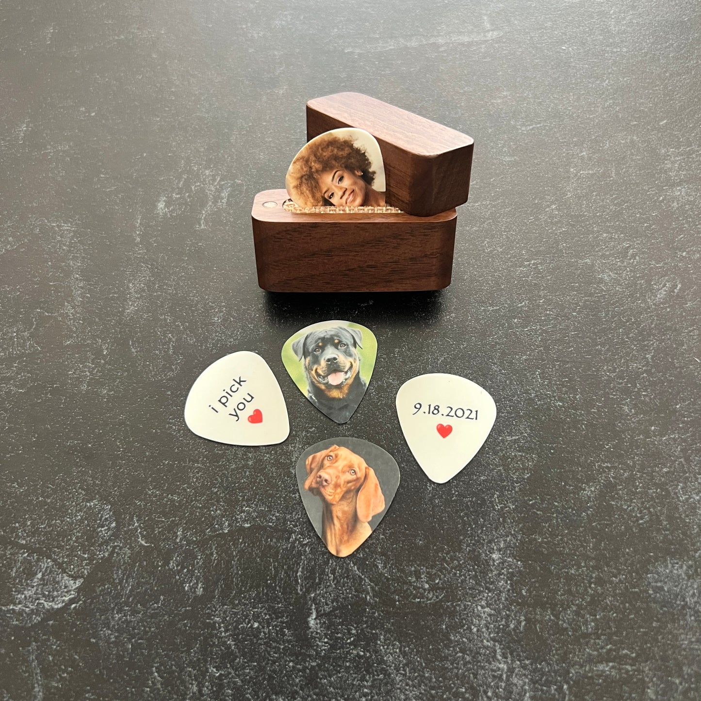Custom color photo guitar picks with personalized image on front and custom text on back, made in South Carolina - shown with photo pick in magnetic wood box and i pick you and a red heart on the back