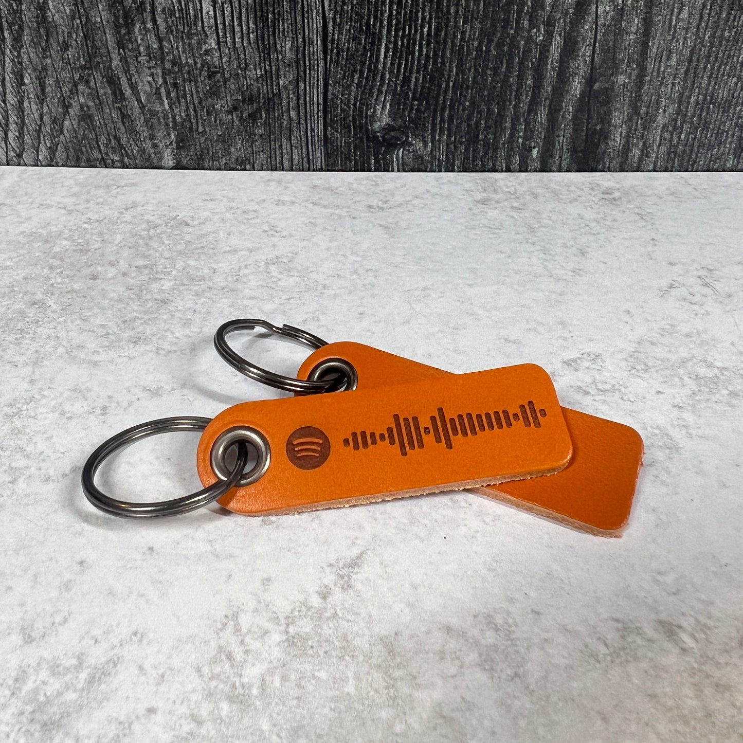 Brown leather keychain with carabiner on a textured surface