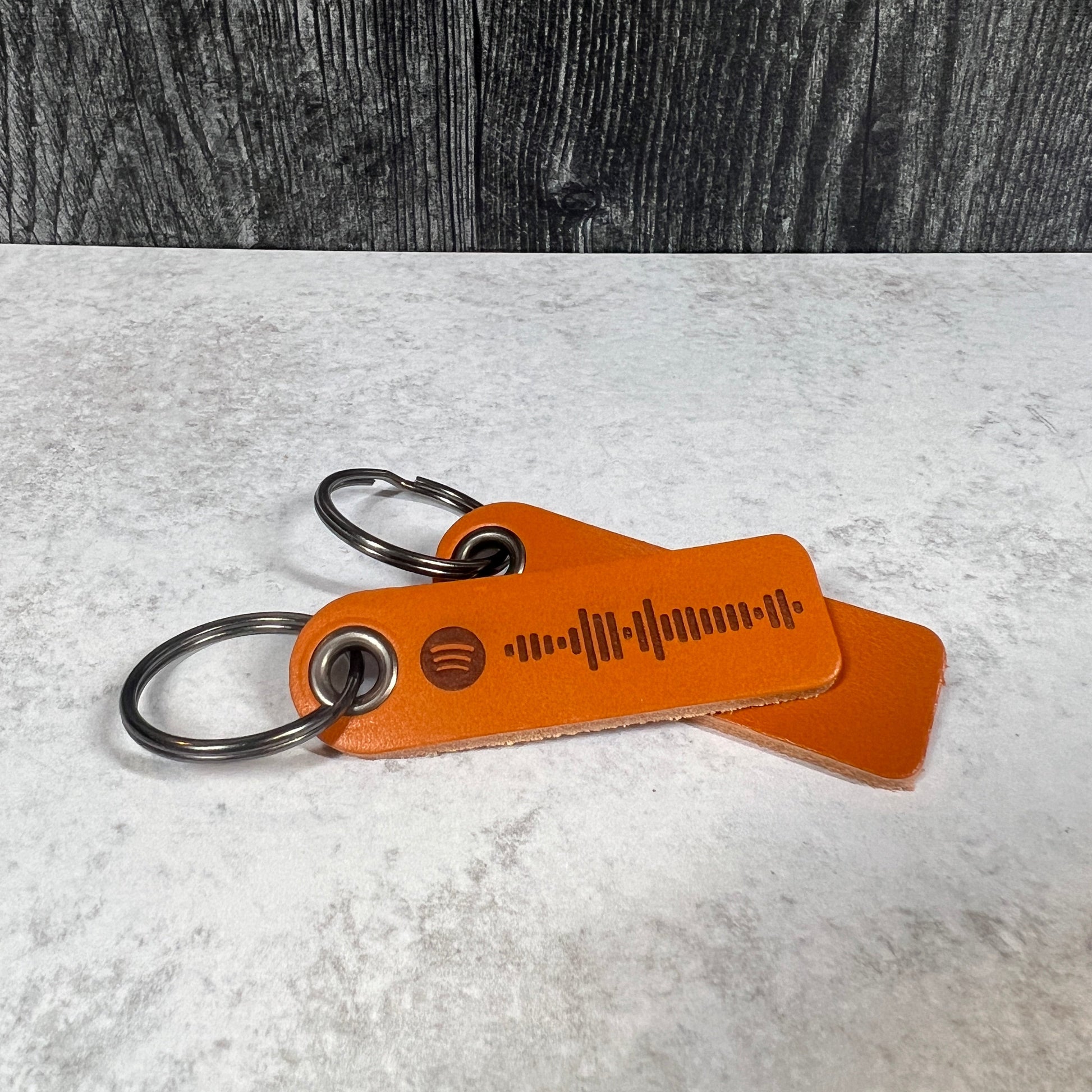 Brown leather keychain with carabiner on a textured surface