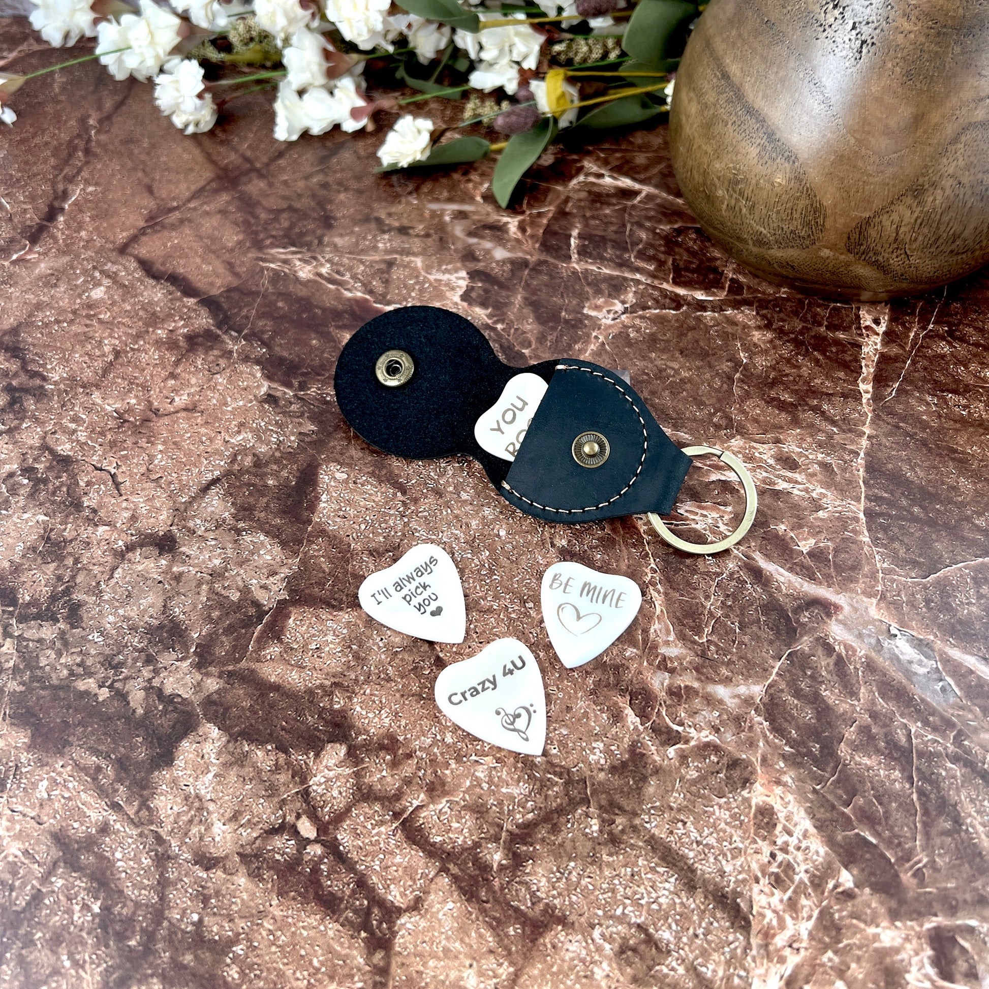 Custom engraved heart-shaped bone guitar pick with personalized text, made in South Carolina